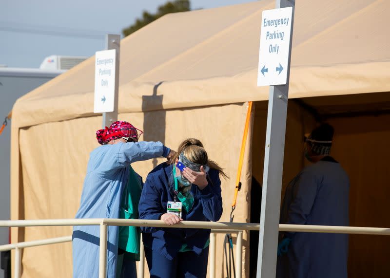 Nurse Stefanie Payan gets a massage from a colleague as healthcare workers work their post at an outdoor triage site in the parking lot of St. Mary Medical Center in California