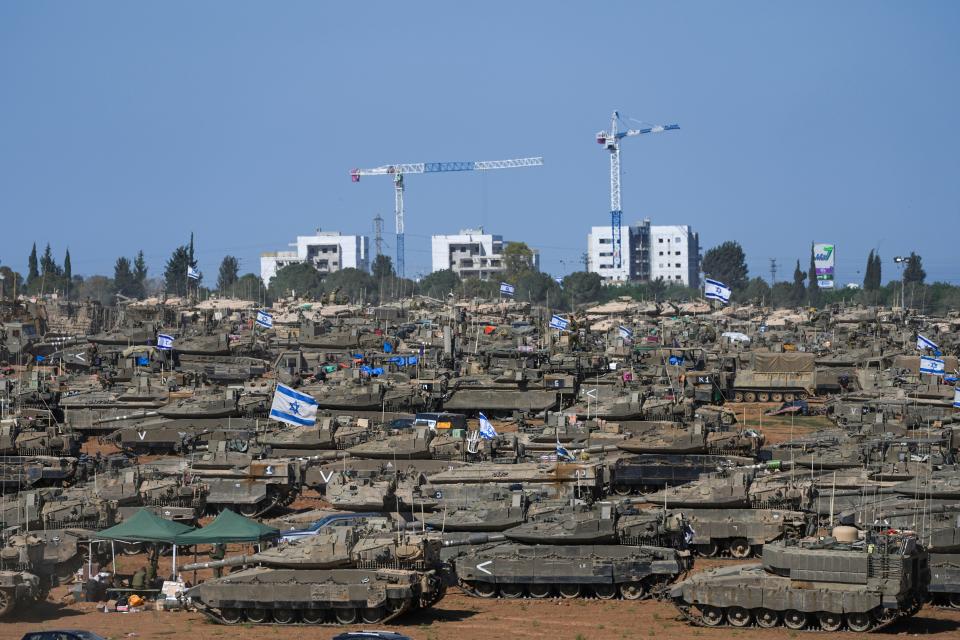 Israeli soldiers work on armored military vehicles at a staging ground near the Israeli-Gaza border, in southern Israel on May 8, 2024.