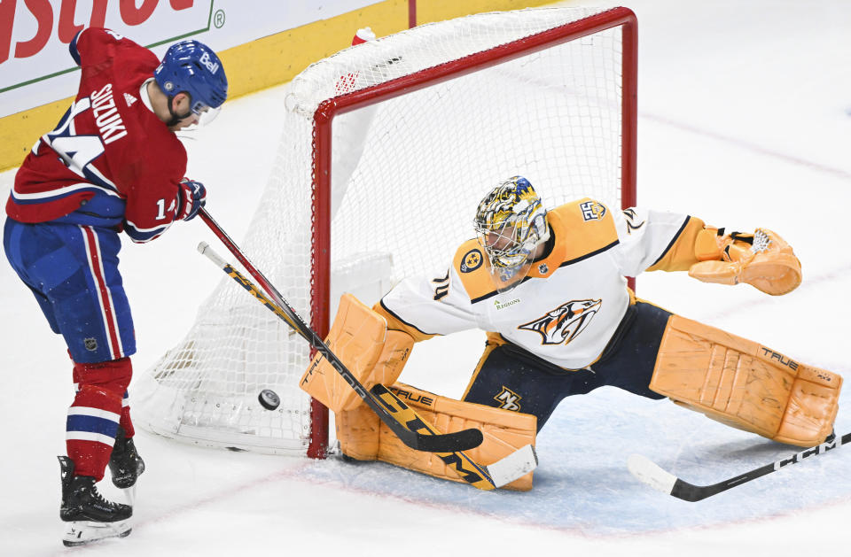 Nashville Predators goaltender Juuse Saros, right, stops Montreal Canadiens' Nick Suzuki (14) during first-period NHL hockey game action in Montreal, Sunday, Dec. 10, 2023. (Graham Hughes/The Canadian Press via AP)