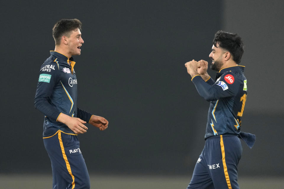 Gujarat Titan's Noor Ahmad, left, celebrates with teammate Rashid Khan the dismissal of Mumbai Indian's Cameron Green during Indian Premier League (IPL) cricket match between Mumbai Indians and Gujarat Titans, in Ahmedabad, India, Tuesday, April 25, 2023.(AP Photo/Ajit Solanki)