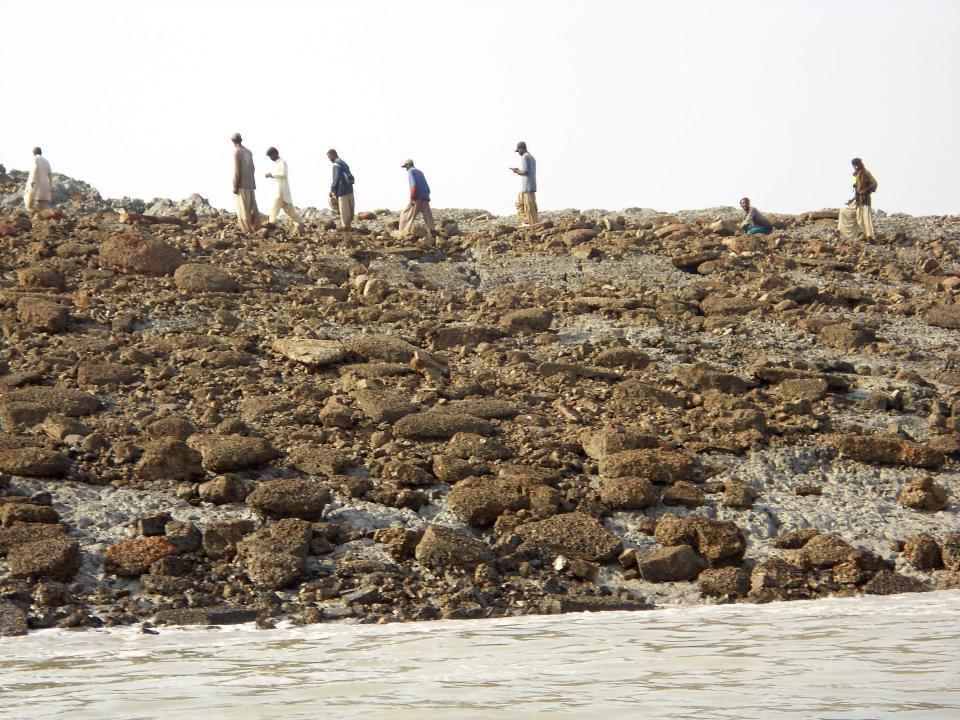 People walk on an island that rose from the sea following an earthquake, off Pakistan's Gwadar coastline in the Arabian Sea September 25, 2013. A major earthquake hit a remote part of western Pakistan on Tuesday, killing at least 45 people and prompting the new island to rise from the sea just off the country's southern coast. The earthquake was so powerful that it caused the seabed to rise and create a small, mountain-like island about 600 meters off Pakistan's Gwadar coastline. Television channels showed images of a stretch of rocky terrain rising above the sea level, with a crowd of bewildered people gathering on the shore to witness the rare phenomenon. (REUTERS)