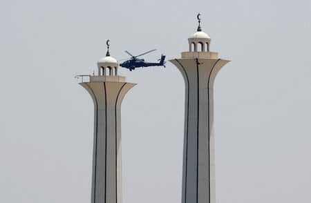 A military helicopter flies near mosque minarets as Pope Francis arrives to hold a mass in Cairo, Egypt April 29, 2017. REUTERS/Amr Abdallah Dalsh