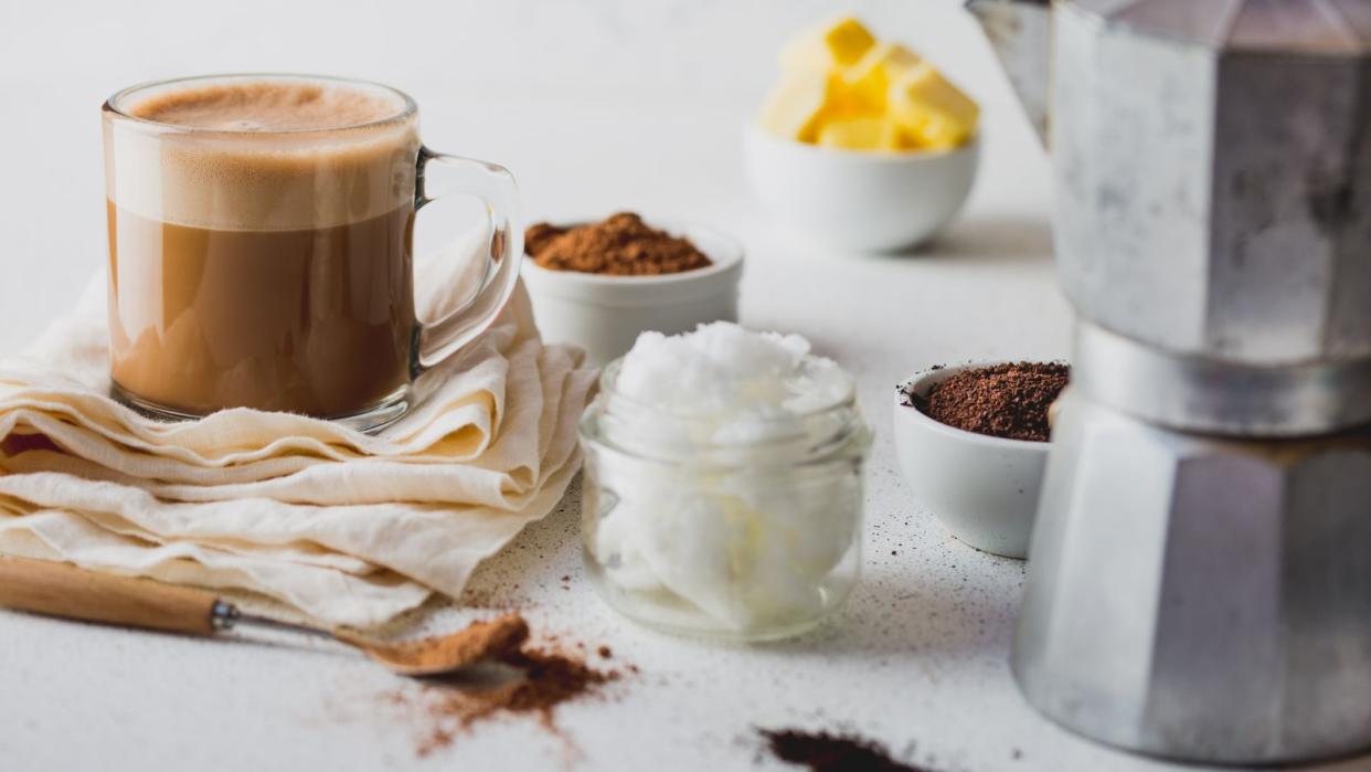  How to make bulletproof coffee: coconut oil, butter, cinnamon and a moka pot around a cup of bulletproof coffee 