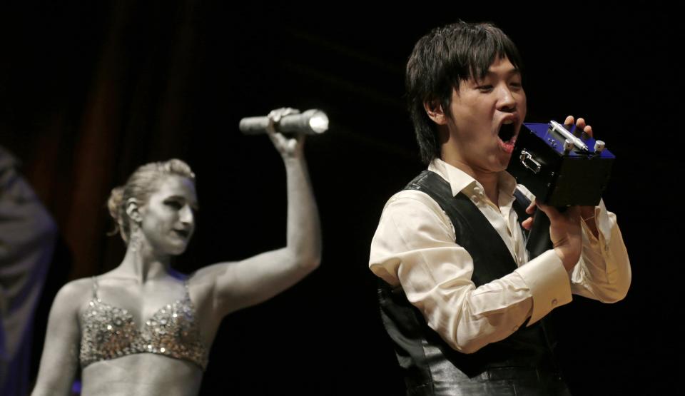 Koji Tsukada yells into his invention the "SpeechJammer" during a performance at the Ig Nobel Prize ceremony at Harvard University, in Cambridge, Mass., Thursday, Sept. 20, 2012. The Ig Nobel prize is an award handed out by the Annals of Improbable Research magazine for silly sounding scientific discoveries that often have surprisingly practical applications. (AP Photo/Charles Krupa)
