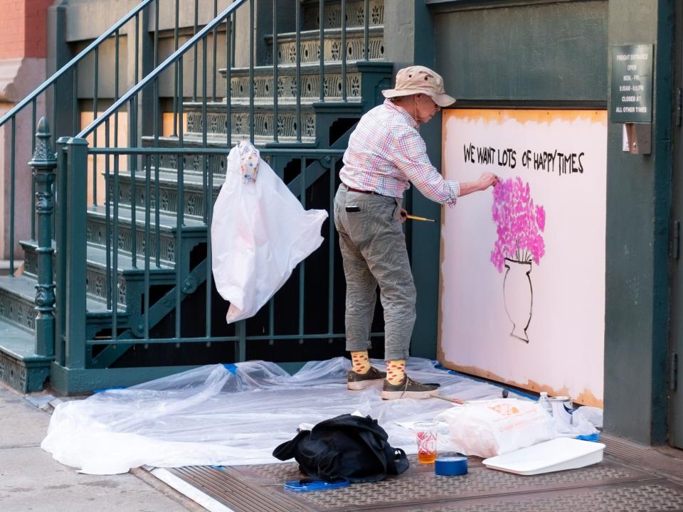 An artist paints on a boarded-up building in SoHo on June 20, 2020 in New York City.