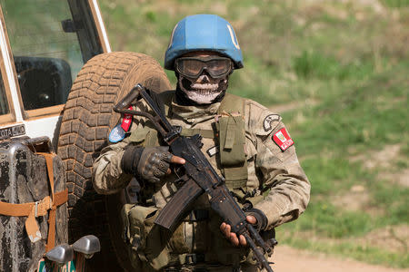 FILE PHOTO: A United Nations peacekeeping soldier provides security during a food aid delivery by the United Nations Office for the Coordination of Humanitarian Affairs and world food program in the village of Makunzi Wali, Central African Republic, April 27, 2017. REUTERS/Baz Ratner/File Photo