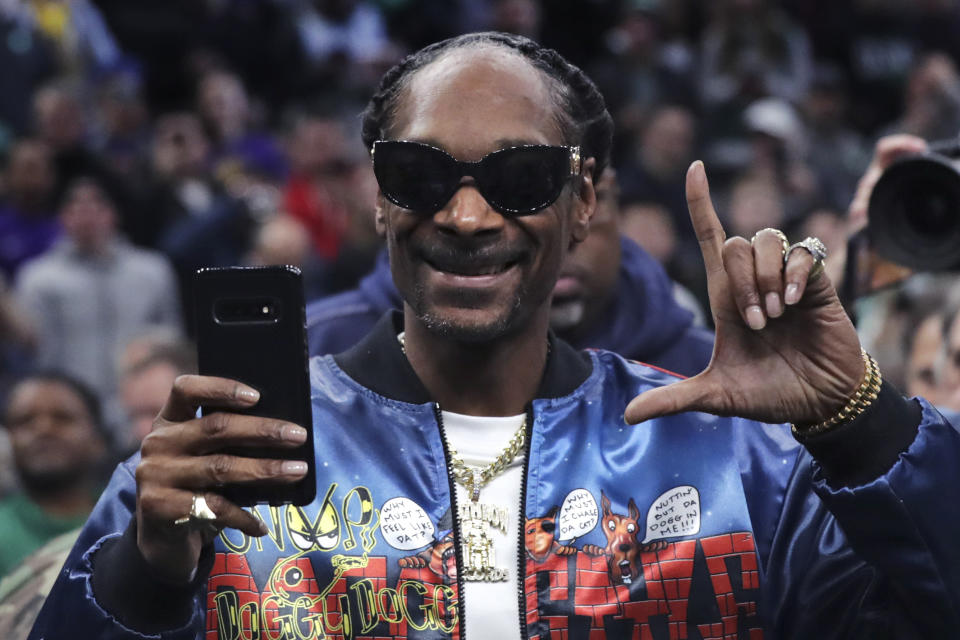 Rapper Snoop Dogg gestures to fans prior to the first half of an NBA basketball game between the Boston Celtics and Los Angeles Lakers in Boston, Monday, Jan. 20, 2020. (AP Photo/Charles Krupa)