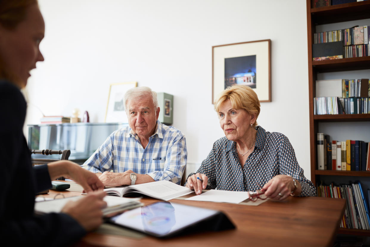 Senior couple listening to their female financial consultant at home. Elderly couple at home meeting with financial advisor.