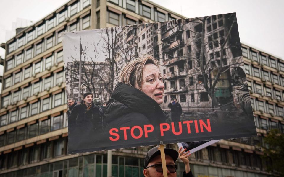 A protester in Belgrade holds up a sign during a demonstration against Russia's military invasion in Ukraine - OLIVER BUNIC/AFP 