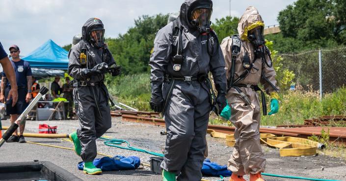 A Philadelphia Fire Department officer and U.S. Army soldiers with the 140th Chemical Company, California National Guard, walk to a railcar to conduct capping operations during chemical spill training within a Dense Urban Terrain exercise at the CSX Railyard in Philadelphia July 27. (1st Lt. Ashley Goodwin/Army)