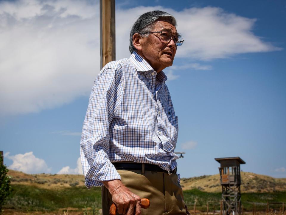 Norman Mineta walks past a recreation of a guard tower at Heart Mountain Japanese internment camp, where he spent part of his youth