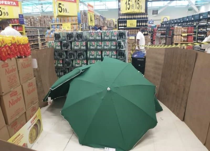 ▲巴西一間家樂福驚傳店員在上班時間猝死，結果賣場卻僅以傘遮蔽遺體後繼續營業，引發外界強烈批評。（圖／翻攝自《Globo》）