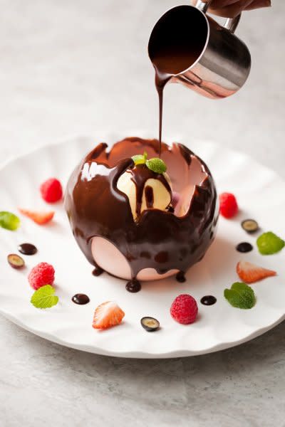 驚奇巧克力球當外層融化瞬間包藏的甜點在眼前綻放，迷人的香氣及繽粉的色彩讓人驚喜萬分。（圖／寒舍艾麗酒店提供）
