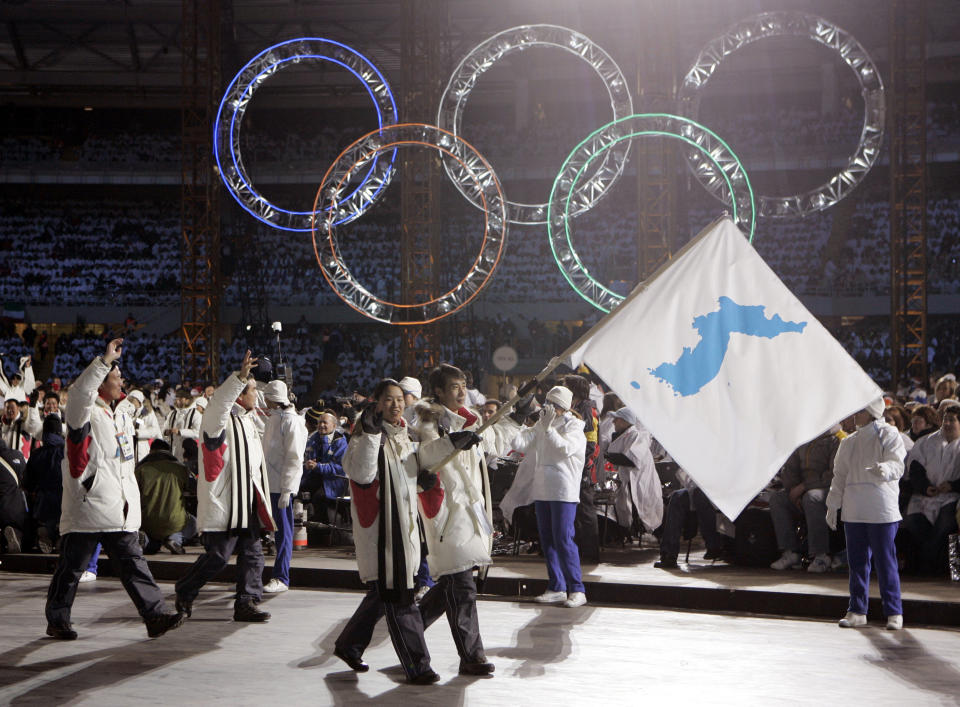 Korea’s flag-bearers, carrying a unification flag, lead their teams into the stadium during the 2006 Winter Olympics opening ceremony in Turin, Italy. North and South Korean agreed Wednesday to allow their athletes to march under the same flag at the Pyeongchang Olympics next month. (AP Photo/Amy Sancetta, File)