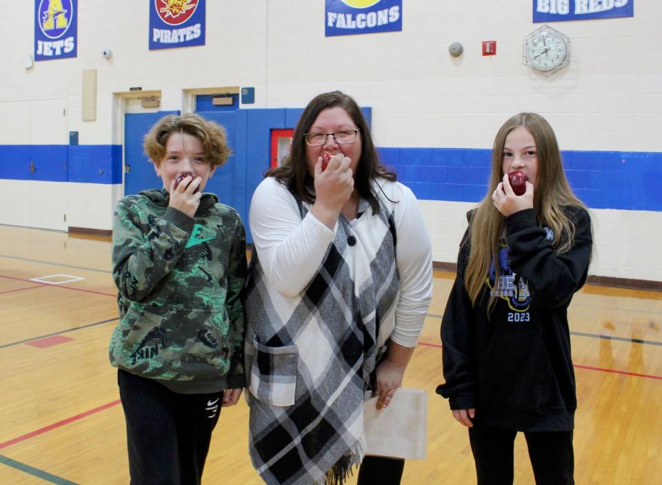 Participating in Great Lakes Great Apple Crunch Day at Jefferson Middle School were (from left) Sixth grader Brock Brown, food service director Jenn Brown and sixth grader Malana Richards.