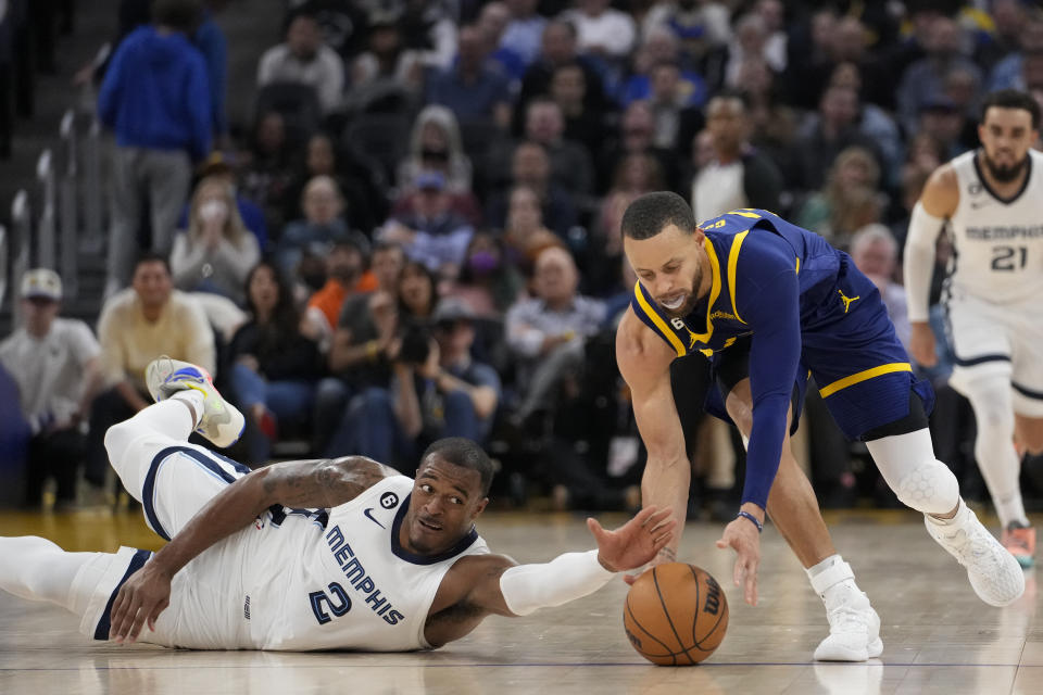 Memphis Grizzlies forward Xavier Tillman Sr., left, and Golden State Warriors guard Stephen Curry compete for possession of the ball during the first half of an NBA basketball game in San Francisco, Wednesday, Jan. 25, 2023. (AP Photo/Godofredo A. Vásquez)