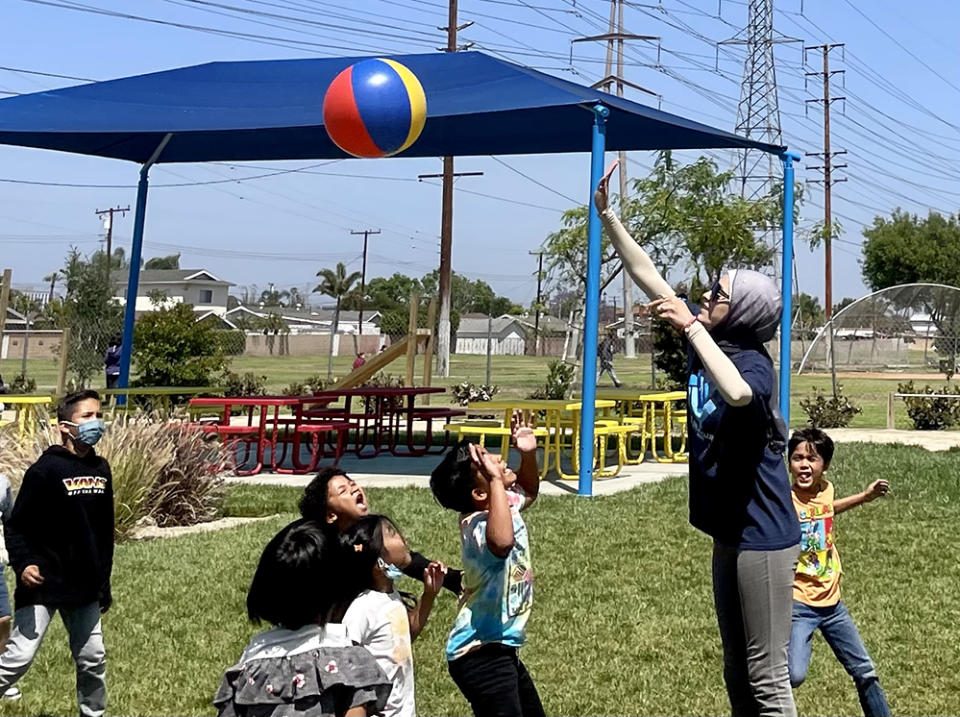 A Boys and Girls Club of Buena Park staff member plays ball with a group of students. (Linda Jacobson)