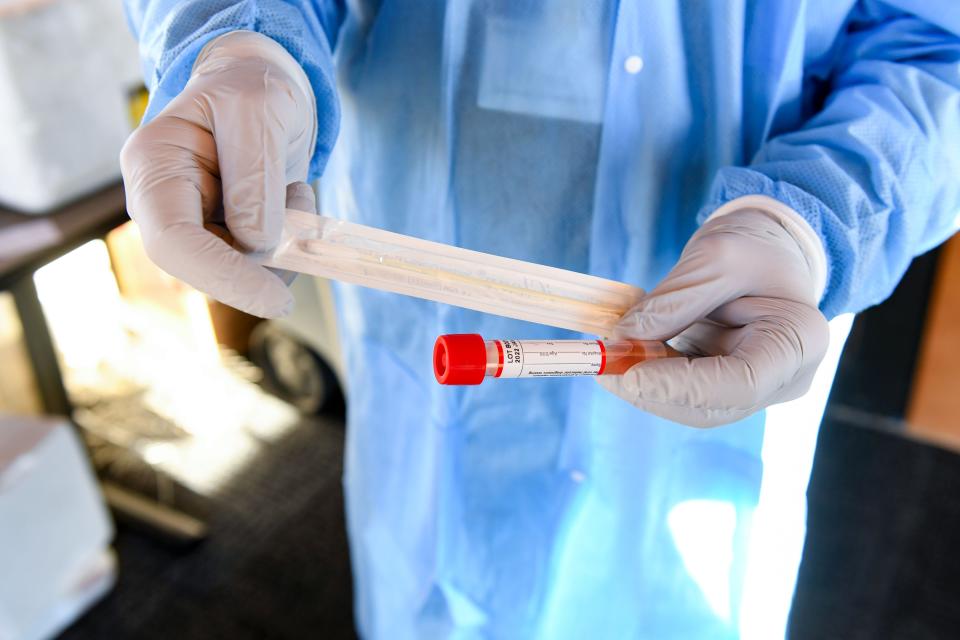Medical testing technician Fred Rule holds a COVID-19 testing swab and tube on Wednesday, January 12, 2022, outside the Avera Institute for Human Genetics in Sioux Falls.