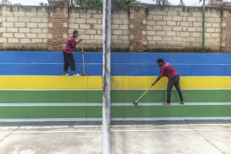 Unos trabajadores limpian las gradas junto a una pista de voleibol en un hostal de Kigali, como parte de los preparativos para recibir a migrantes procedentes del Reino Unido, el 24 de abril de 2024 en la capital ruandesa (Guillem Sartorio)