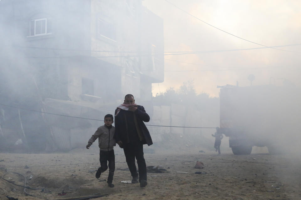 Palestinos corren luego de un ataque israelí contra un edificio residencial en Rafah, el lunes 19 de febrero de 2024. (AP Foto/Hatem Ali)