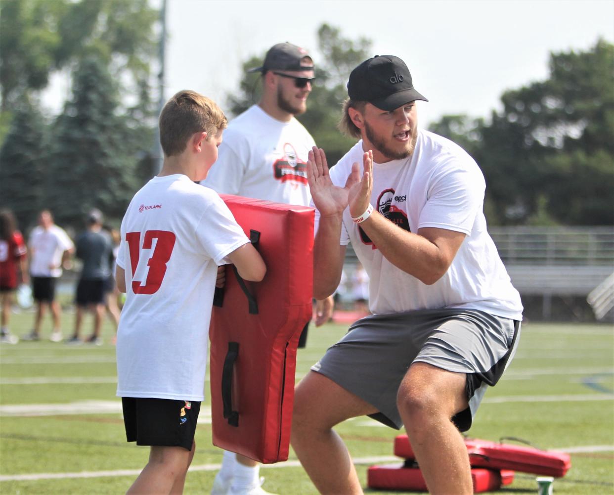 Former Wisconsin offensive lineman Nolan Rucci demonstrates blocking technique during the second-annual Chimere Dike football camp at Waukesha North High School on Saturday June 17, 2023 in Waukesha, Wis.