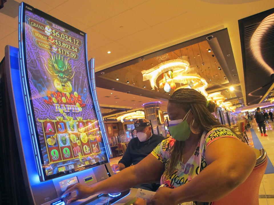 In this May 3, 2021, photo, a woman plays a slot machine in the Hard Rock casino in Atlantic City N.J. On Monday, Dec. 6, 2021, new state Senate President Steve Sweeney said four of Atlantic City's nine casinos are in danger of closing if the state Legislature does not pass a tax break bill for the casinos that was advanced Monday through a Senate committee. (AP Photo/Wayne Parry)