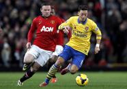 Manchester United's Wayne Rooney (L) chases Arsenal's Mesut Ozil during their English Premier League soccer match at Old Trafford in Manchester, northern England, November 10, 2013.