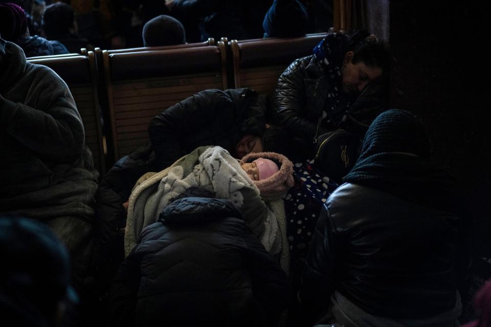 A baby sleeps while people trying to flee Ukraine wait for trains inside Lviv railway station, Monday, Feb. 28, 2022, in Lviv, west Ukraine.