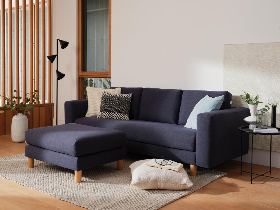  A loungeroom scene showing a navy 3-seat Lounging Sofa with matching ottoman