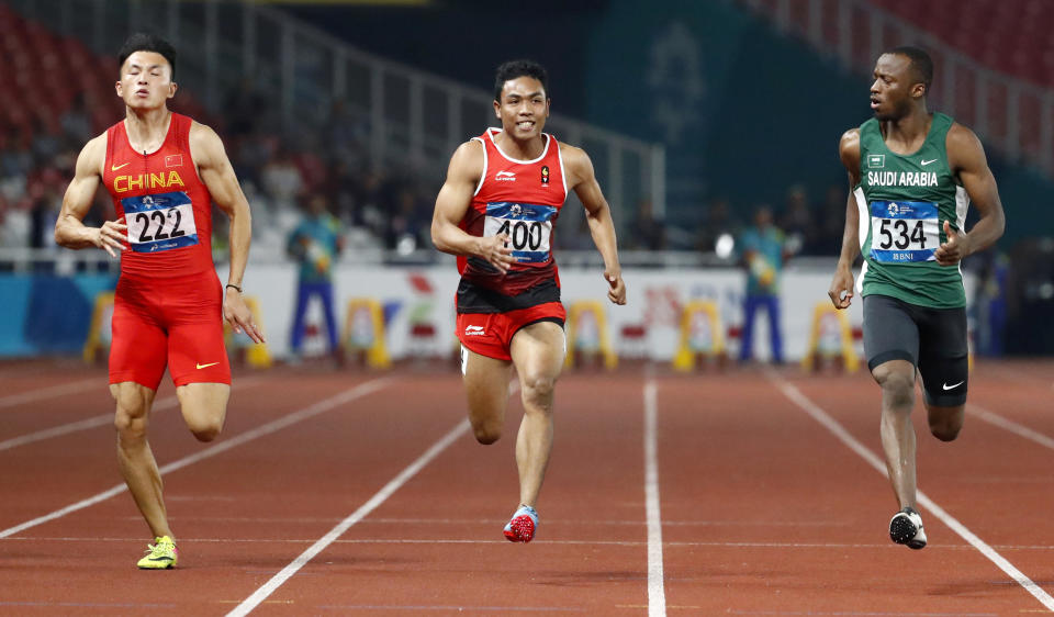 China's Xu Zhouzheng, left, Indonesia's Lalu Muhammad Zohri and Saudi Arabia's Abdullah Abkar Mohammed, right, run in their men's 100m semifinal during the athletics competition at the 18th Asian Games in Jakarta, Indonesia, Sunday, Aug. 26, 2018. (AP Photo/Bernat Armangue)