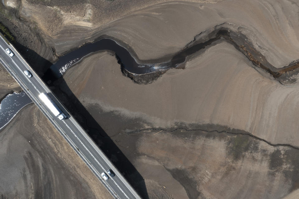 Traffic crosses a bridge at Woodhead Reservoir in West Yorkshire, England, Monday, July 18, 2022, as water levels dip dangerously low amid record high temperatures in the UK. This was the year war returned to Europe, and few facets of life were left untouched. Russia’s invasion of its neighbor Ukraine unleashed misery on millions of Ukrainians, shattered Europe’s sense of security, ripped up the geopolitical map and rocked the global economy. The shockwaves made life more expensive in homes across Europe, worsened a global migrant crisis and complicated the world’s response to climate change. (AP Photo/Jon Super)