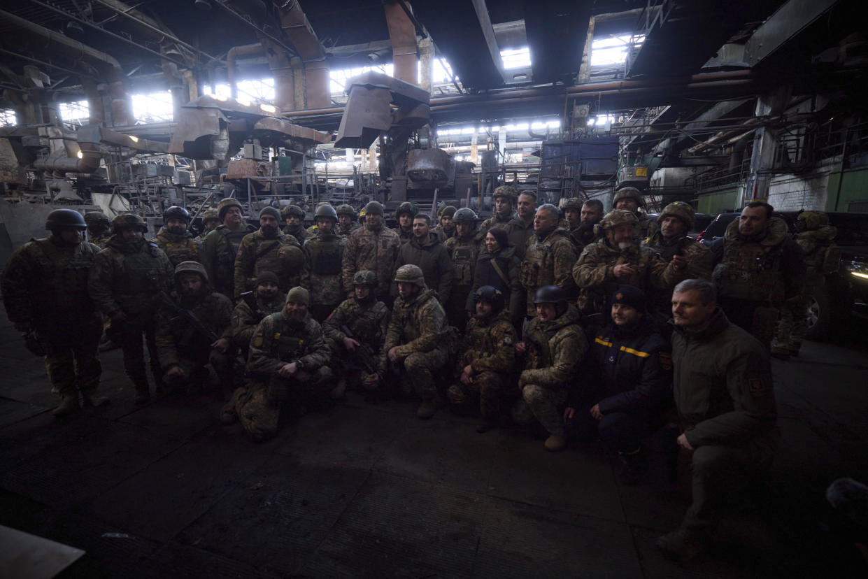 In this photo provided by the Ukrainian Presidential Press Office, Ukrainian President Volodymyr Zelenskyy, center, poses for photo with soldiers at the site of the heaviest battles with the Russian invaders in Bakhmut, Ukraine, Tuesday, Dec. 20, 2022. (Ukrainian Presidential Press Office via AP)