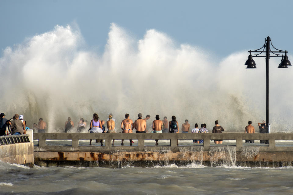 Curious residents of Key West, Fla., flock to the Edward B. Knight Pier Monday, Aug. 24, 2020, to witness the wind and wave action of Hurricane Laura as the storm passes well to the west of the Florida Keys. (Rob O'Neal/The Key West Citizen via AP)