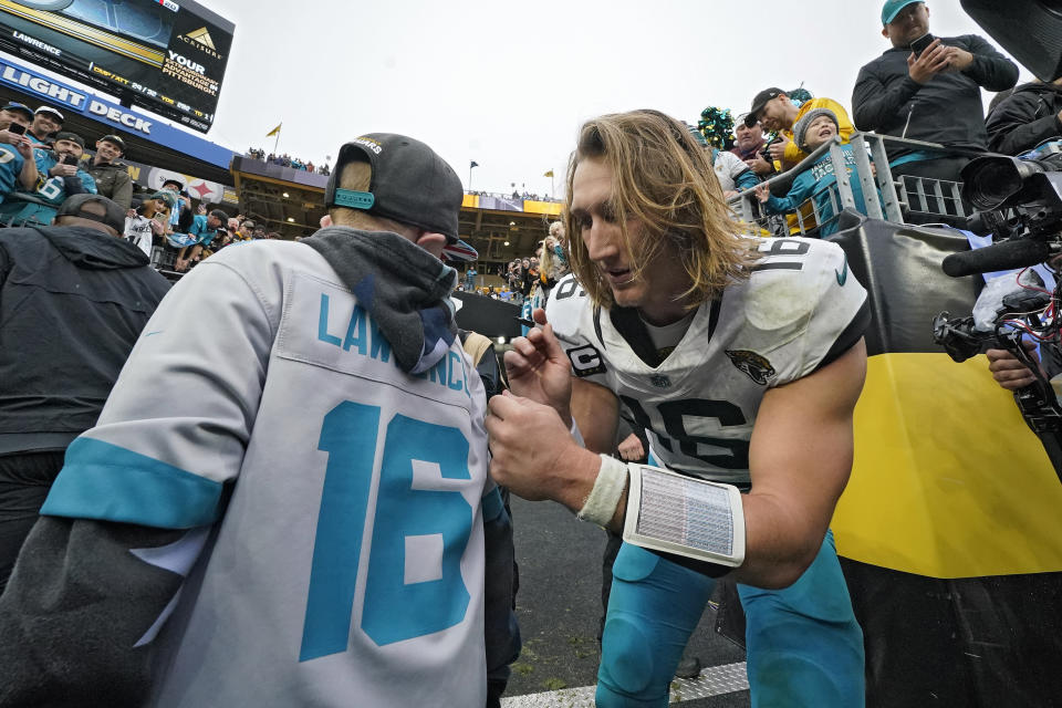 Jacksonville Jaguars quarterback Trevor Lawrence (16) signs Huddy Bates's jersey after an NFL football game against the Pittsburgh Steelers Sunday, Oct. 29, 2023, in Pittsburgh. (AP Photo/Gene J. Puskar)