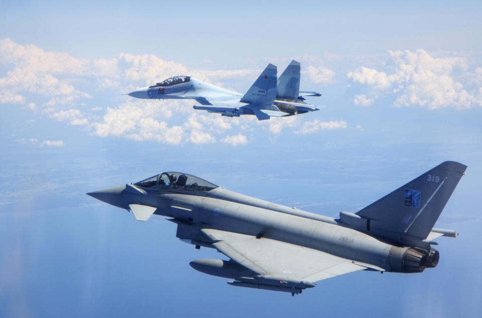 CAPTION CORRECTS AIRCRAFT NAME - In this photo taken on Saturday, June 15, 2019, a Royal Air Force Typhoon jet, bottom, flies by a Su-30 Flanker fighter. Two Royal Air Force jets deployed in Estonia have been scrambled twice in recent days, bringing the number of intercepts of Russian aircraft to eight since taking over the Baltic Air Policing mission in early May. The Typhoon jets were alerted Friday to intercept a Russian Su-30 Flanker fighter, and passed a military transport craft as it was escorting the fighter over the Baltic Sea. In a second incident on Saturday, RAF crews intercepted a Su-30 Flanker fighter and an Ilyushin Il-76 Candid transport aircraft that was traveling north from the Russian enclave of Kaliningrad toward Estonian and Finnish airspace. (UK Ministry of Defence via AP)