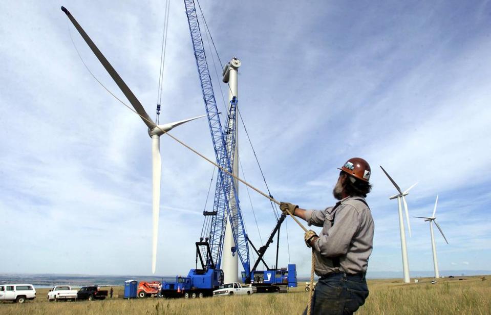 Ironworker Don Anderson steadies a wind turbine blade as it’s lifted into place at the Nine Canyon Wind Farm south of Kennewick in 2002.