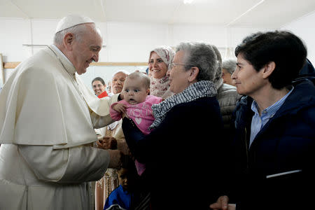 Pope Francis touches child's head during a visit to a rural social service run by the Daughters of Charity of St. Vincent de Paul in Temara, near Rabat, Morocco March 31, 2019. Vatican Media/­Handout via REUTERS