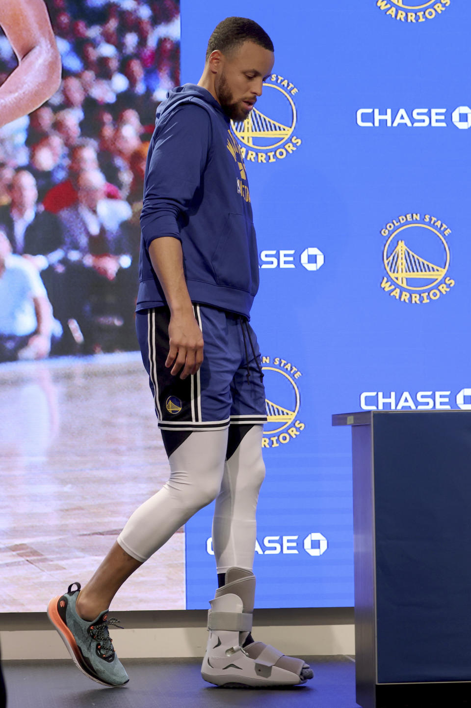 Golden State Warriors guard Stephen Curry walks into a press conference to speak to the media about his injury before an NBA basketball game against the San Antonio Spurs in San Francisco, Sunday, March 20, 2022. (AP Photo/Jed Jacobsohn, Pool)