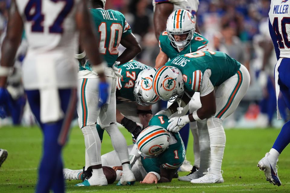 Sep 12, 2024; Miami Gardens, Florida, USA; Miami Dolphins offensive tackle Liam Eichenberg (74) and tight end Jonnu Smith (9) attend to quarterback Tua Tagovailoa (1) after an apparent injury during the second half against the Buffalo Bills at Hard Rock Stadium. Mandatory Credit: Jasen Vinlove-Imagn Images