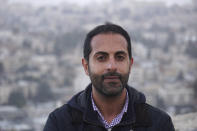 Lawyer Alaa Mahajna poses for a photo on Mount Scopus, overlooking Jerusalem, on Saturday, Feb. 9, 2019. Mahajna was one of at least half a dozen people targeted by a mysterious group of undercover operatives over the past couple of months. All of them have crossed paths, in some way, with the NSO Group, a spyware maker that Mahajna is suing in Israeli court. (AP Photo/Raphael Satter)