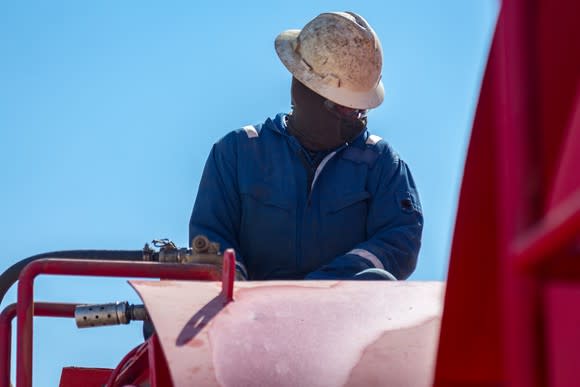 Oil-rig worker at pump.