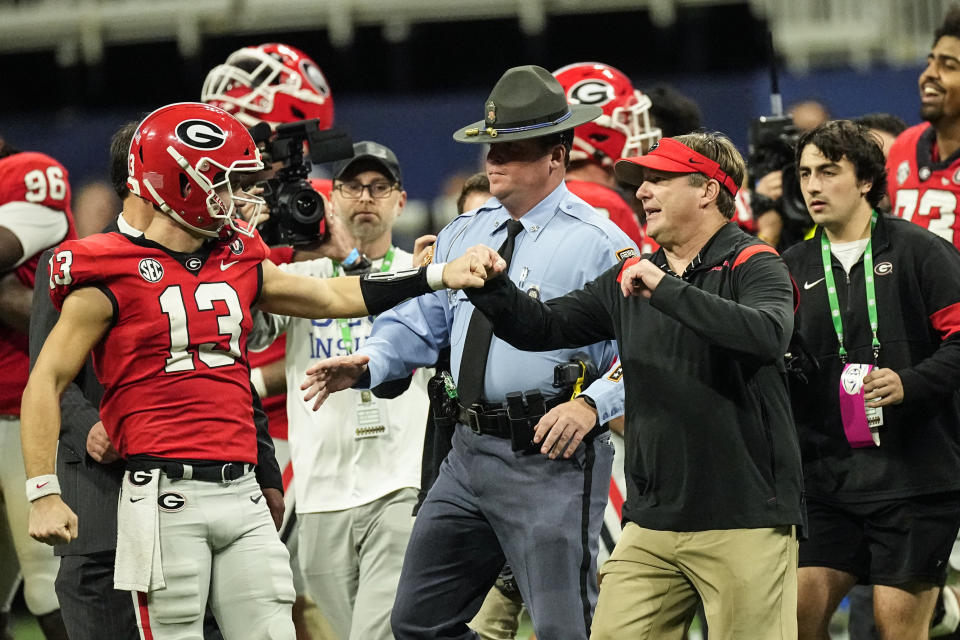 Georgia head coach Kirby Smart and Georgia quarterback Stetson Bennett (13) celebrate after defeating LSU in the Southeastern Conference Championship football game Saturday, Dec. 3, 2022 in Atlanta. (AP Photo/John Bazemore)