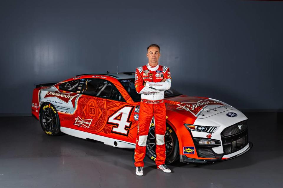 Kevin Harvick poses in front of his throwback Budweiser-themed Ford Mustang that he will drive Sunday at Homestead.