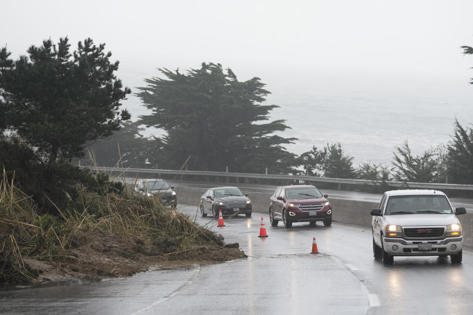 A northbound lane of Highway 1 is closed due to a landslide, Thursday, Jan. 5, 2023, in Pacifica, Calif. Damaging winds and heavy rains from a powerful "atmospheric river" pounded California on Thursday, knocking out power to tens of thousands, causing flash flooding, and contributing to the deaths of at least two people, including a child whose home was hit by a falling tree. (AP Photo/Godofredo A. Vásquez)