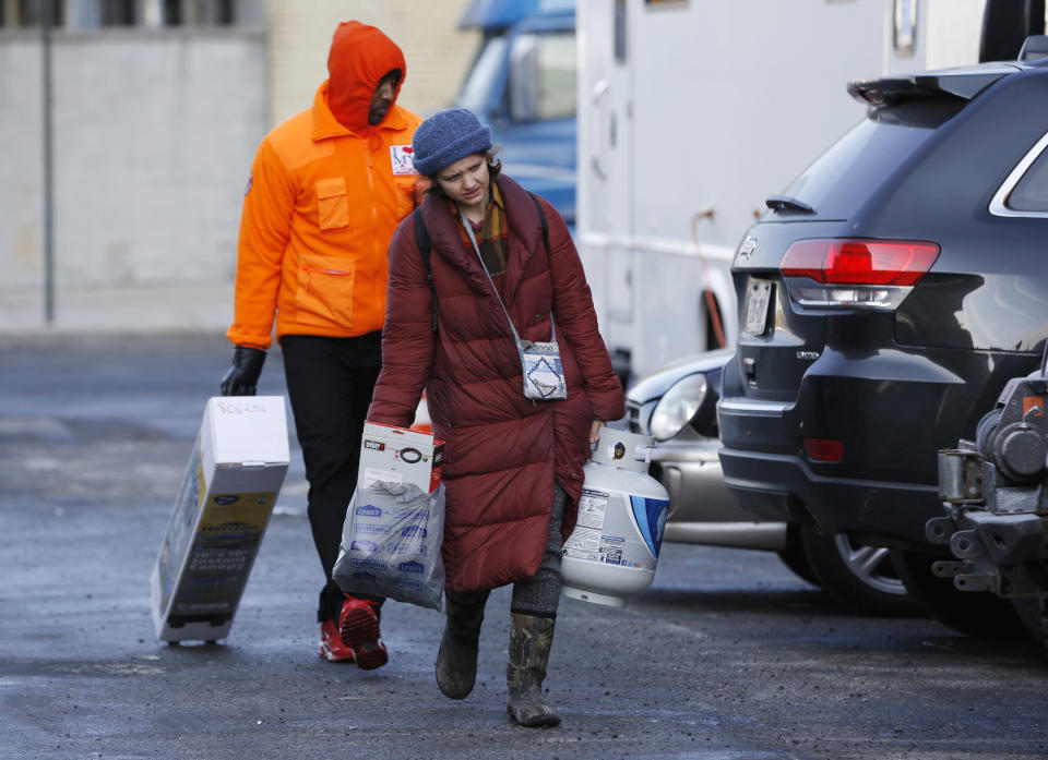 Volunteers bring donated supplies for prisoners' family members, protesters and activists who are maintaining a vigil outside the Metropolitan Detention Center, a federal facility where prisoners have been without heat, hot water, electricity and proper sanitation due to an electrical failure since earlier in the week, Sunday, Feb. 3, 2019, in New York. (AP Photo/Kathy Willens)