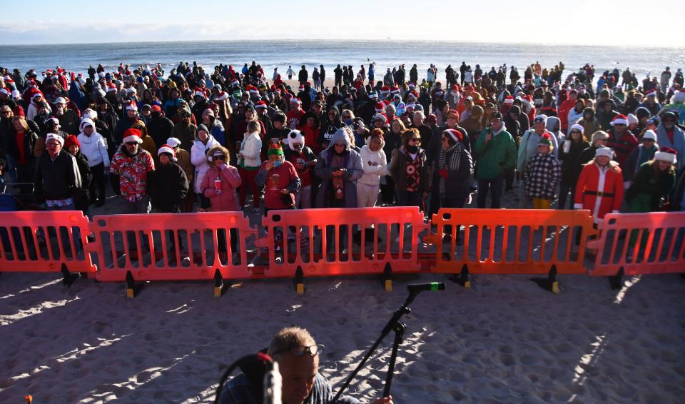 Thousands of spectators showed up on a chilly Christmas Eve morning for Surfing Santas festivities in Cocoa Beach. stretching along the sand across a couple of city blocks.