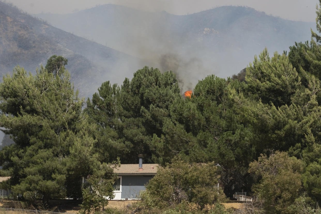 The Apple Fire burning behind a house in Banning, Calif., in August 2020.