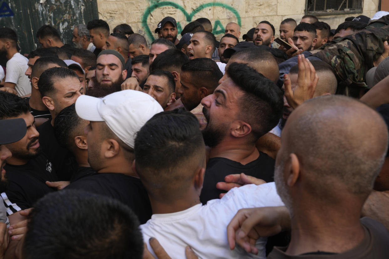Palestinians carry the body of Ibrahim al-Nabulsi, top right, in the West Bank town of Nablus, Tuesday, Aug. 9, 2022. Israeli police said forces encircled the home of Ibrahim al-Nabulsi, who they say was wanted for a string of shootings in the West Bank earlier this year. They said al-Nabulsi and another Palestinian militant were killed in a shootout at the scene, and that troops found arms and explosives in his home. Palestinian health officials said three persons were killed and at least 40 wounded in the gun battle on Tuesday. (AP Photo/Majdi Mohammed)