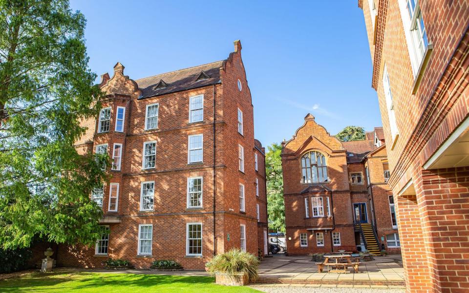 The red brick buildings of Linacre College are seen on a sunny day