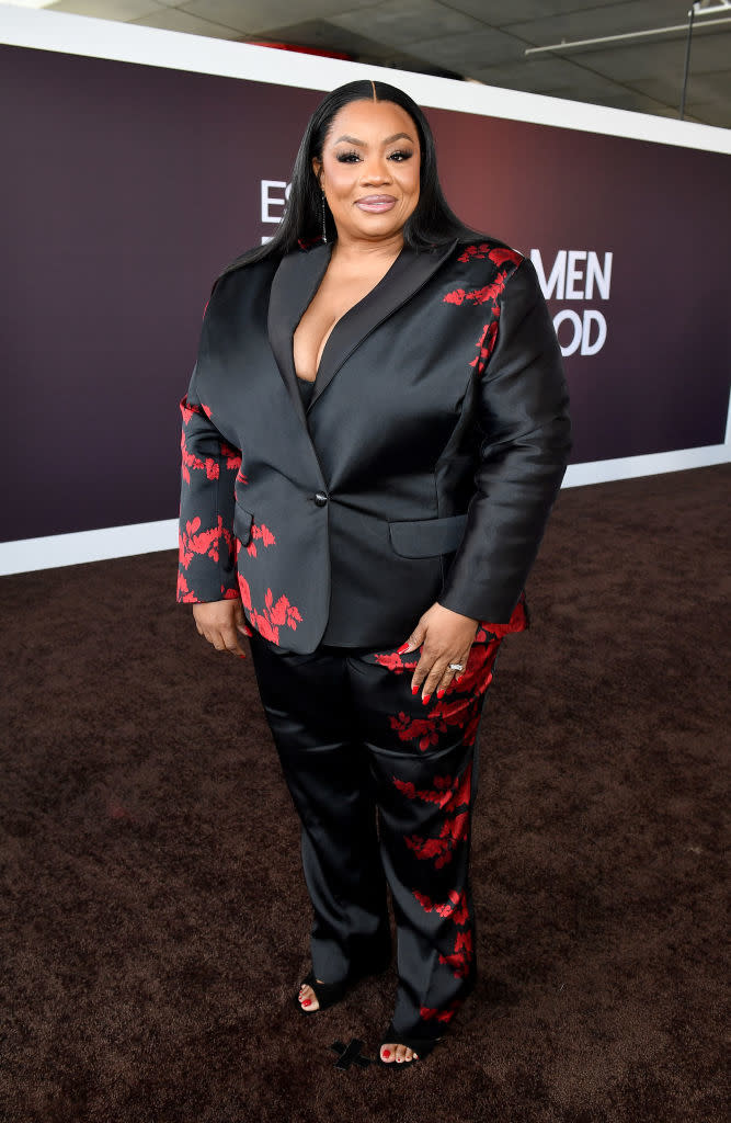 Ms. Pat in a suit with floral pattern, posing on the event carpet